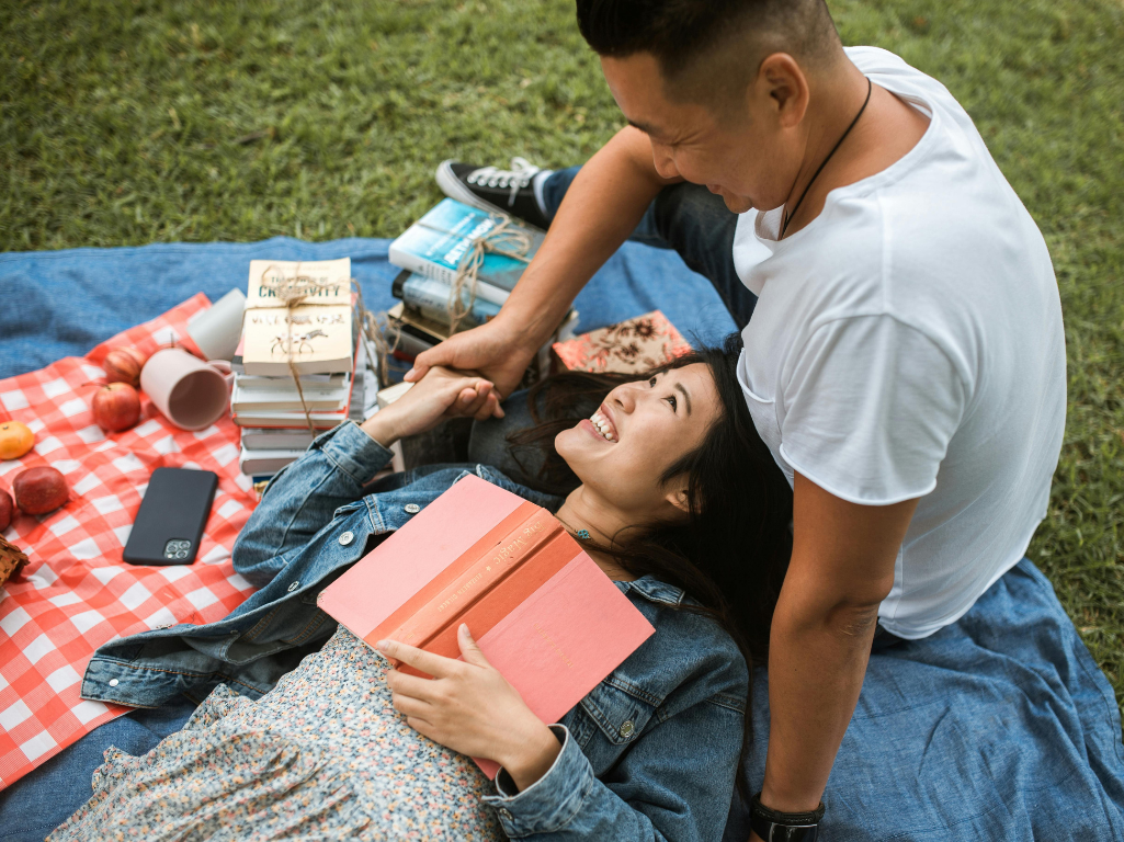A couple reading books as the Park.