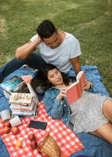 A couple reading books as the Park.