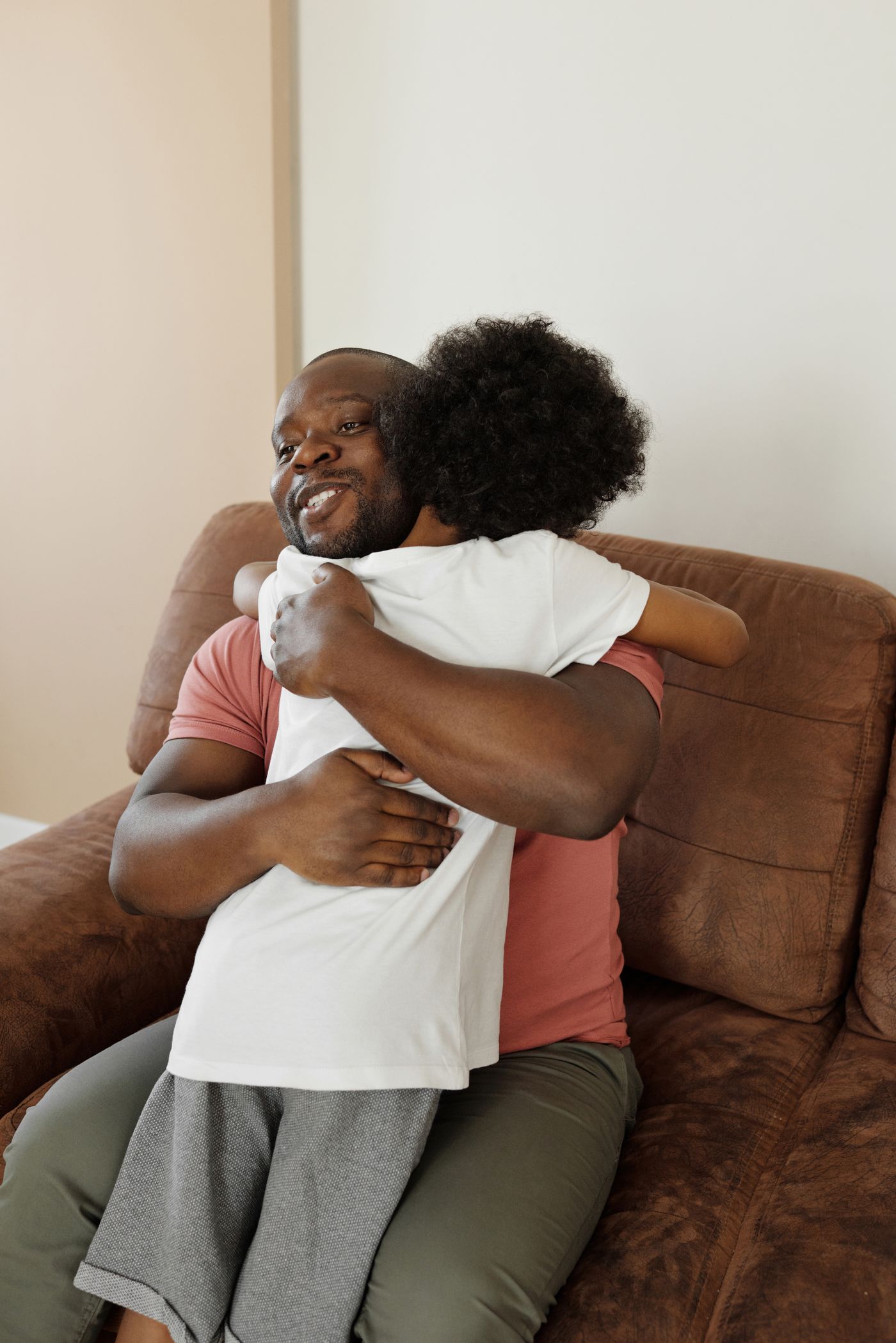 Father hugging his child on a couch at home